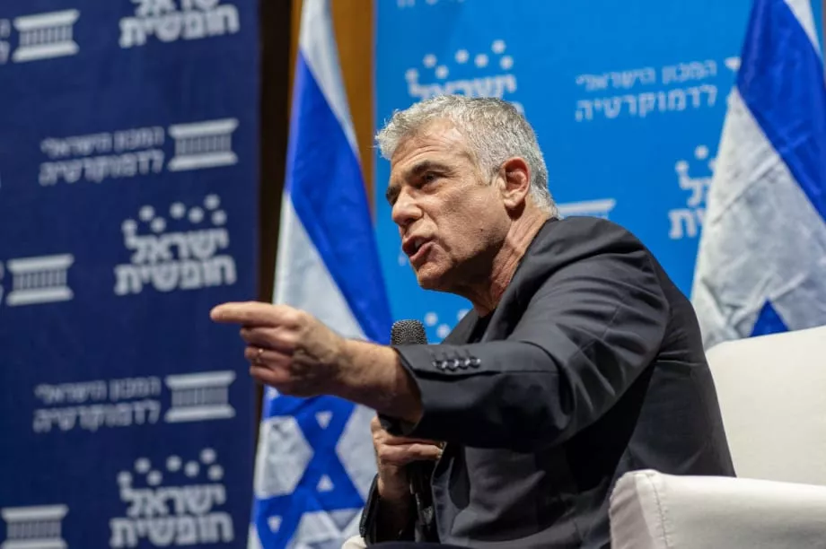 תמונה של יאיר לפיד מדבר בפאנל עם מקרופון
